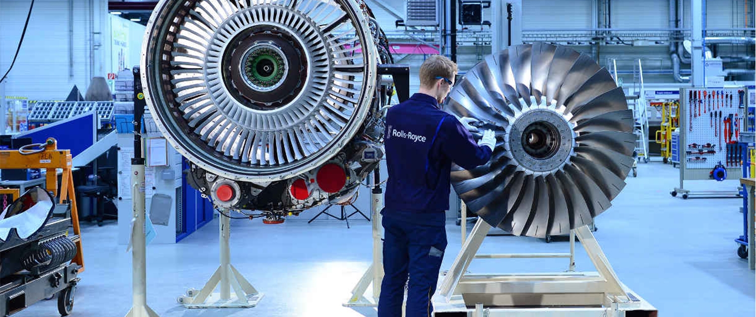 Ein Mitarbeiter von Rolls Royce arbeitet an einer Turbine.