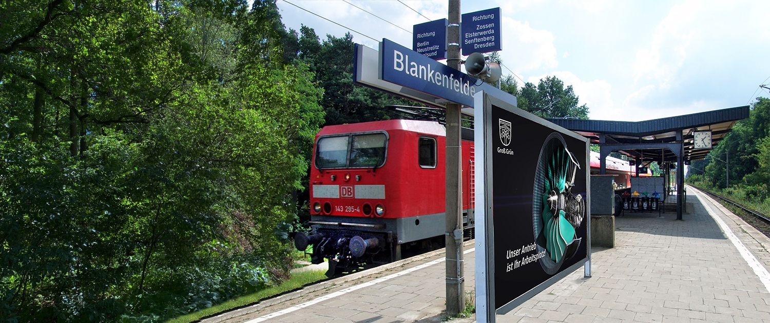 Eine Werbe Plakat für die Gemeinde Blankenfelde-Mahlow am Bahnhof Blankenfelde, mit der Aufschrift "Unser Antrieb ist Ihr Arbeitsplatz" und im Hintergrund ist eine Turbine zu sehen.