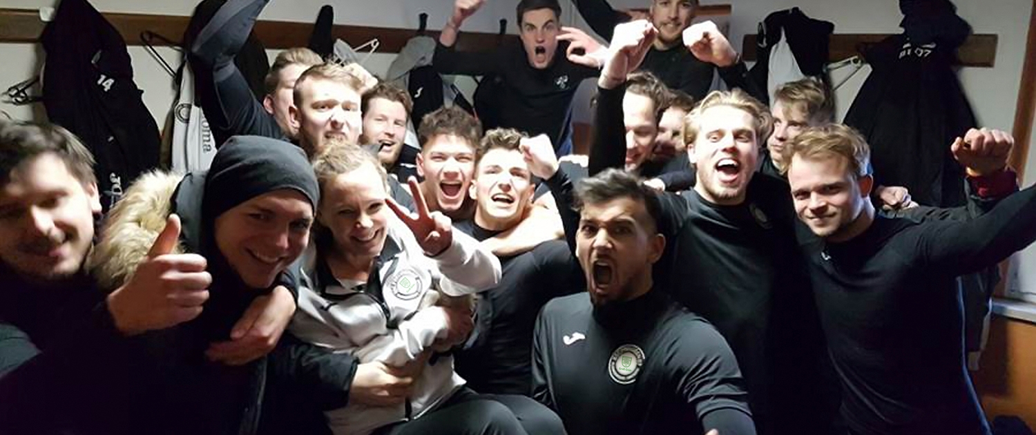 Eine Gruppe Sportler in der Umkleide versammelt.