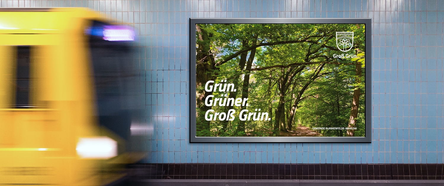 Ein Plakat im U-Bahnhof mit der Aufschrift "Grün, Grüner, Groß Grün" und im Hintergrund eine Wald.