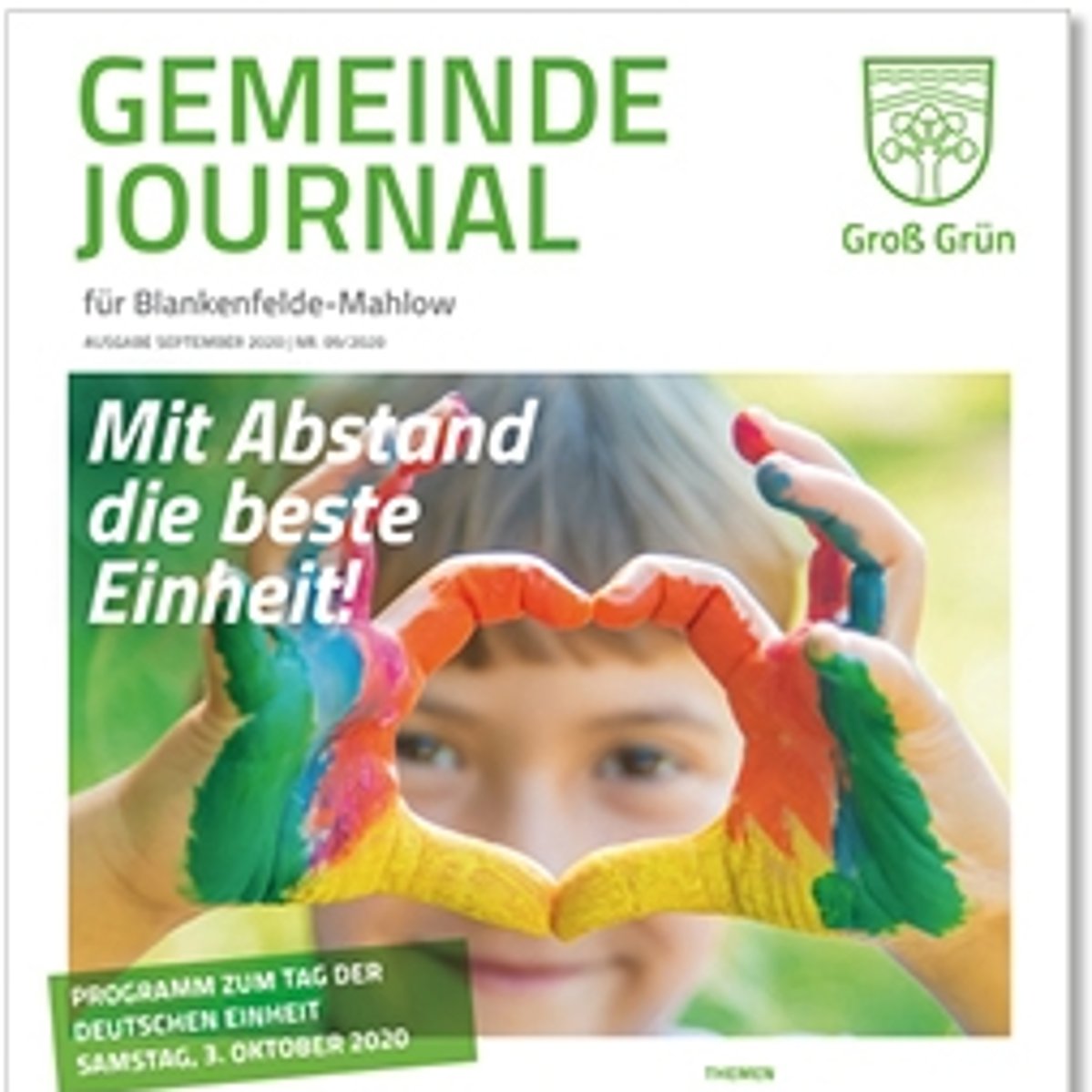 Fröhliches Kind mit bemalten Fingern zum Herz geformt