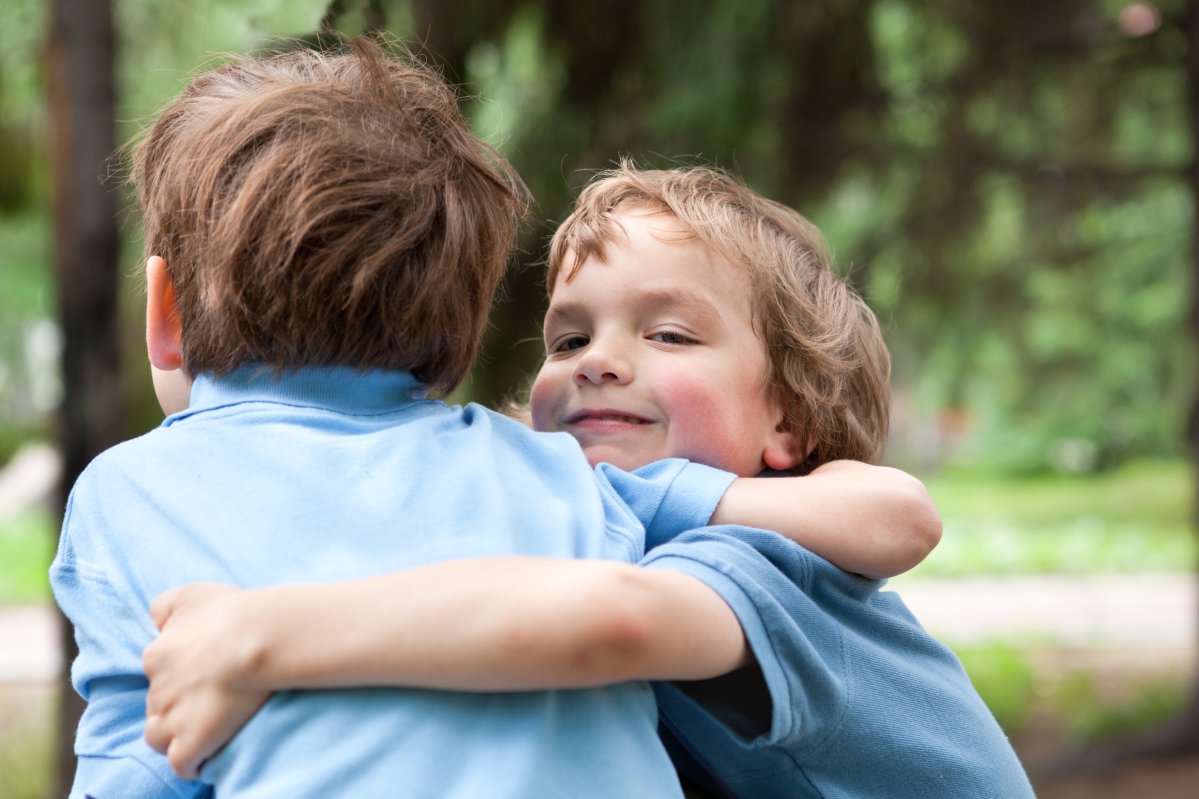 Two brothers hugging in park