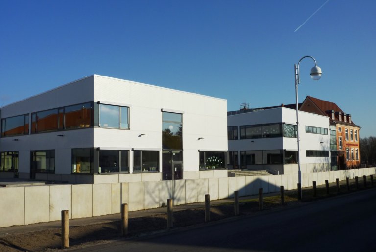 Das Gebäude der Astrid Lindgren Schule in Blankenfelde, mit vielen Fenstern und weißer Fassade.