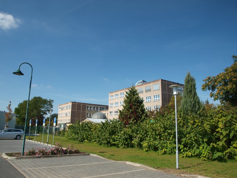 Das Gebäude der Herbert Tschäpe Oberschule in Dahlewitz, mit braun und grauer Fassade.